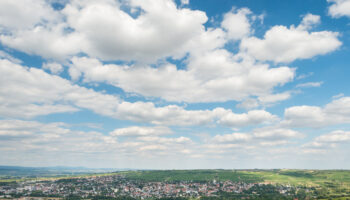 RHT-Hiwweltouren-2013-001-Bismarckturm Blauer Himmel mit Wolken ,in der Ferne ein Ort im Vordergrund Waldflächen