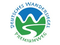 Logo Deutsches Wandersiegel Premiumweg Rundes Logo mit der Aufschrift „Deutsches Wandersiegel Premiumweg“. In der Mitte sind stilisierte grüne Hügel, ein weißer geschwungener Weg und ein blauer Himmel zu sehen.
