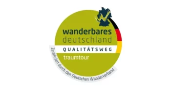 Logo Qualitaetsweg wanderbares Deutschland, © Deutscher Wanderverband Rundes grün-weißes Siegel mit der Aufschrift „wanderbares deutschland“, „Qualitätsweg“ und „traumtour“. Am Rand steht „Zertifiziert durch den Deutschen Wanderverband“.