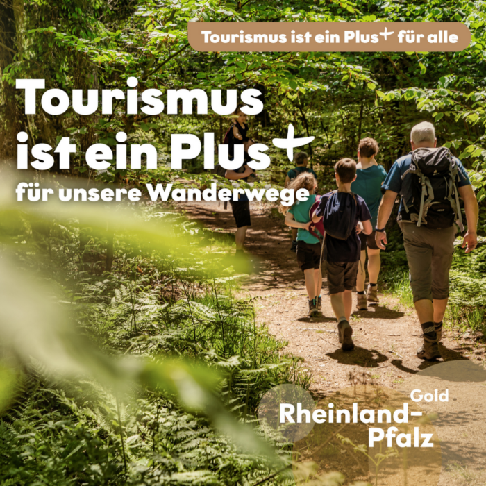 Mehrere Erwachsene und Kinder wandern auf einem schmalen Weg durch einen grünen Wald. Im Vordergrund trägt ein Mann einen Rucksack. Darüber steht „Tourismus ist ein Plus+ für unsere Wanderwege“.